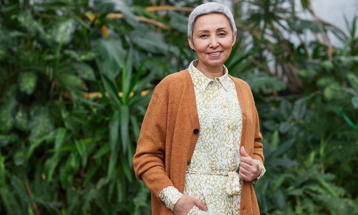 A healthy, smiling woman in midlife outdoors