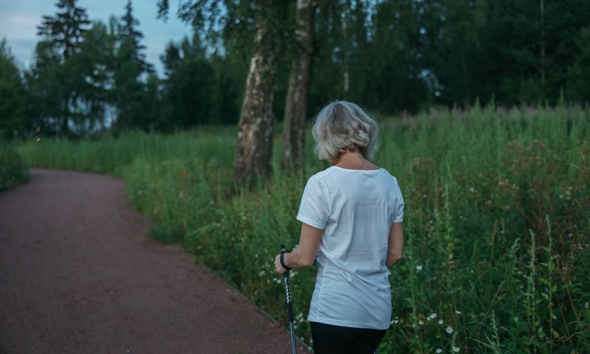 A woman in midlife walking outdoors for exercise